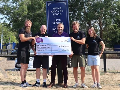 Team holding a cheque for money raised